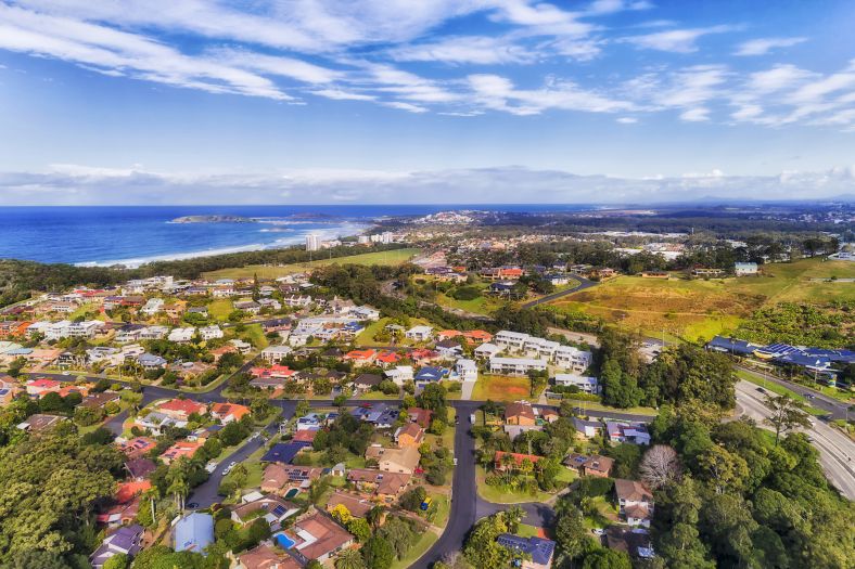 Ariel view of Regional NSW in Coffs Harbour. Landscape of trees, street with houses and the ocean.