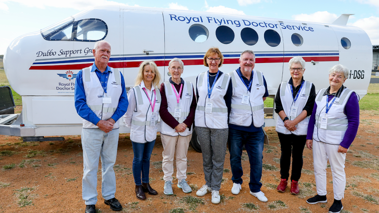 group of flying doctors volunteers standing in front of a small plane