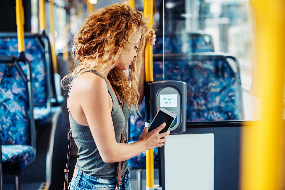 Woman scanning digital Opal card on bus