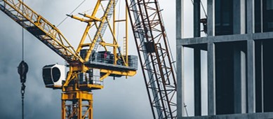 An image of cranes overlooking a large scale construction site
