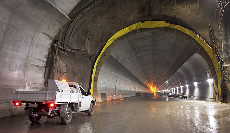 Tunnel under construction and white truck on foreground