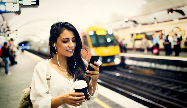 Women on phone in underground train station smiling