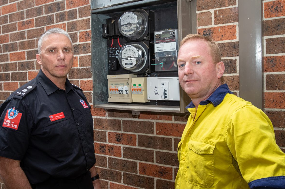 firefighter and electrician at circuit board