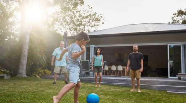A family playing soccer in a backyard