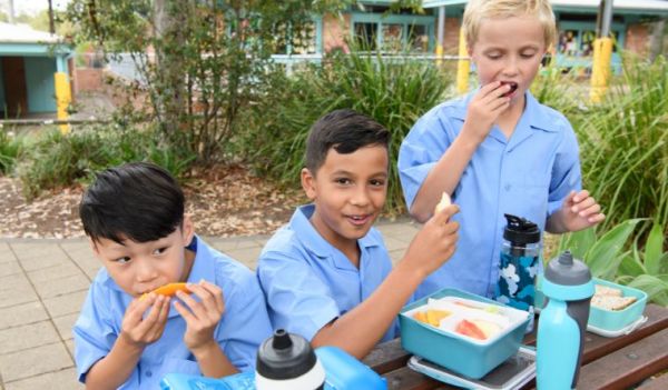 Three boys eat their lunch outside at a NSW primary school