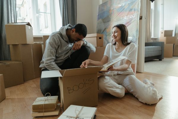 A couple sat on the floor with a moving box