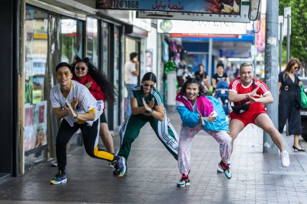 The Pioneers, a Powerhouse Youth Theatre Inc performance group dancing on a street