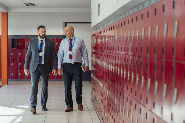 Two teachers walking in a school corridor