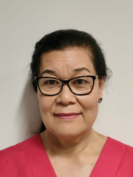 Close up of a woman in a pink shirt and black glasses