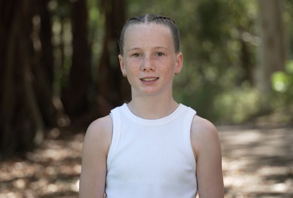 Young girl in a white singlet looking into the camera