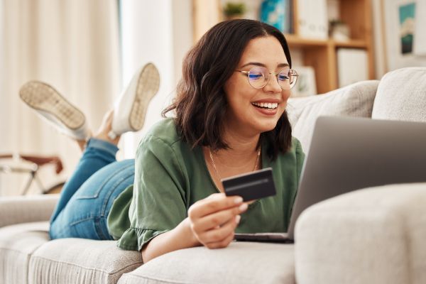 Woman on laptop holding credit card