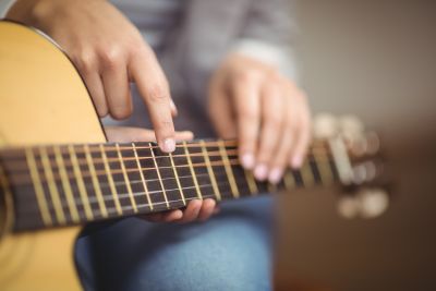 Image of man's hands playing a guitar 