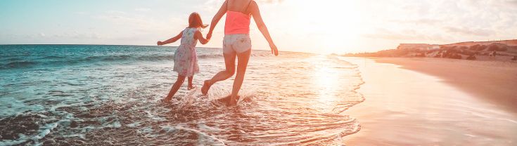 Mother-and-daughter-walking-on-a-beach