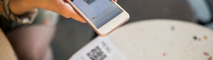 Close up image of a person using a QR code
