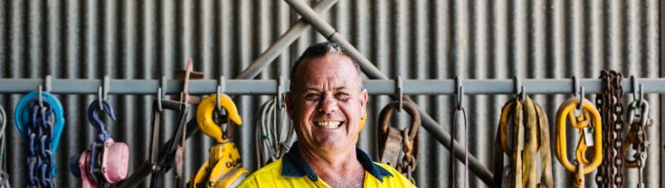 Worker smiling in shed with tools