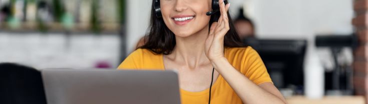 Female with headphones on looking at laptop
