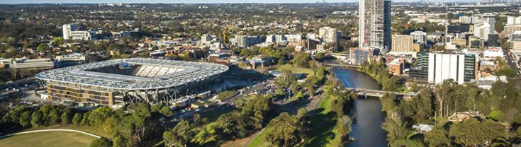 Aerial image overlooking Parramatta. The left half of the image features green space surrounding Bankwest Stadium, Parramatta and the right half of the image features the Parramatta River and the Parramatta CBD