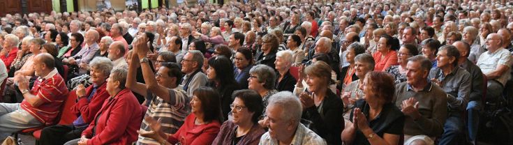Side shot of audience seated in rows in Sydney Town Hall - all beaming and happy at the jokes delivered for the comedy show