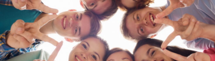 teenagers smiling and looking down in a circle