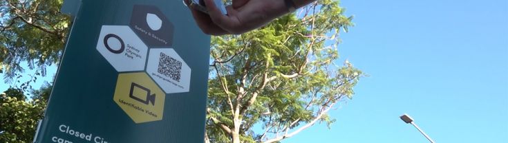 A person scans the QR code on a Digital Trust for Places Routines sign in Sydney Olympic Park.