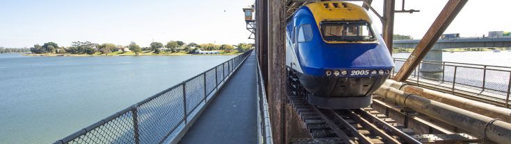 An XPT Train crosses a bridge over water.
