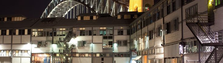 The Walsh Bay precinct looking up towards the Sydney harbour bridge at night time. 