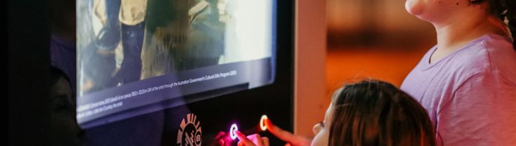 Kids interacting with a touchscreen device.