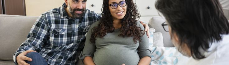 Pregnant woman with partner and health practitioner