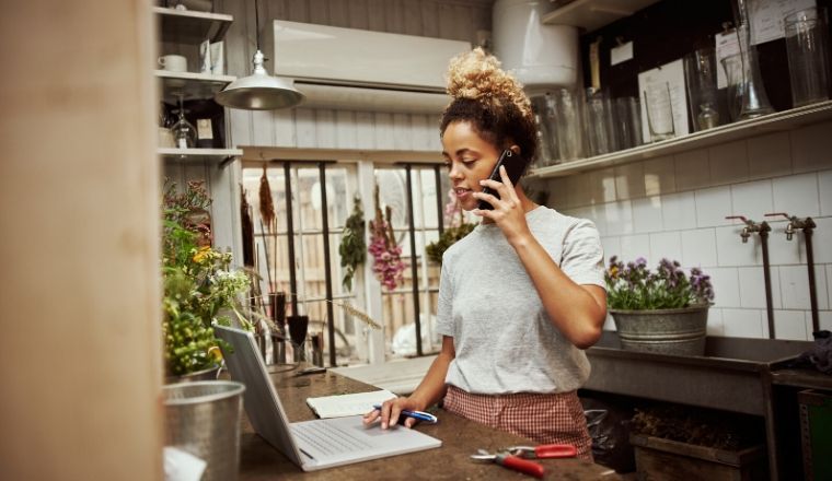 Young woman on her mobile phone working in a small business
