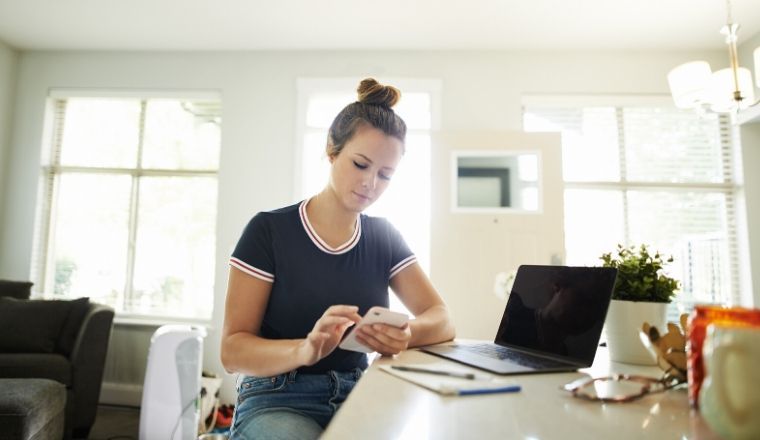 Young woman using a mobile phone while working at home