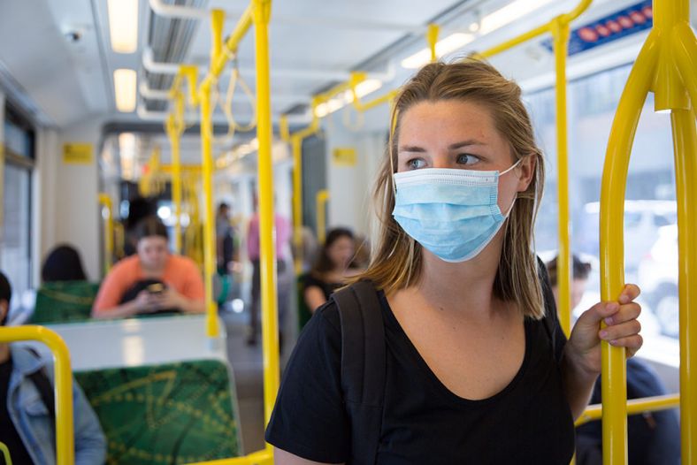 Person wearing a face mask on public transport