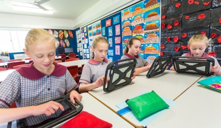 Students using tablets inside an Australian classroom