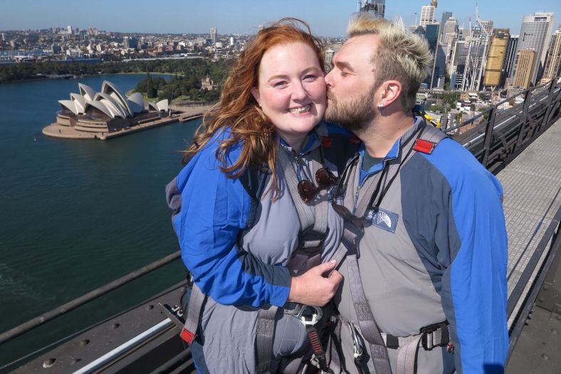 Happily married couple kissing at the top of the Harbour Bridge