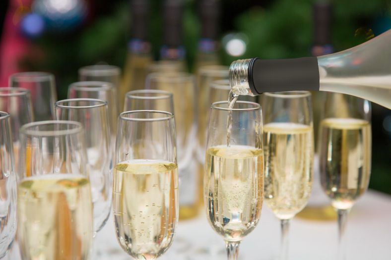 Champagne glasses being filled with champagne or sparkling wine