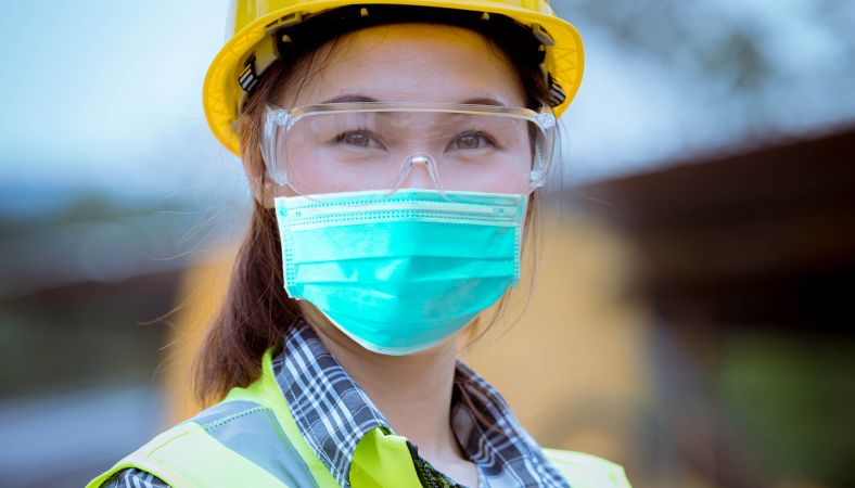 Construction worker in mask and safety equipment