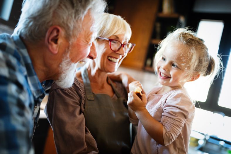 Grandparents laughing with young child