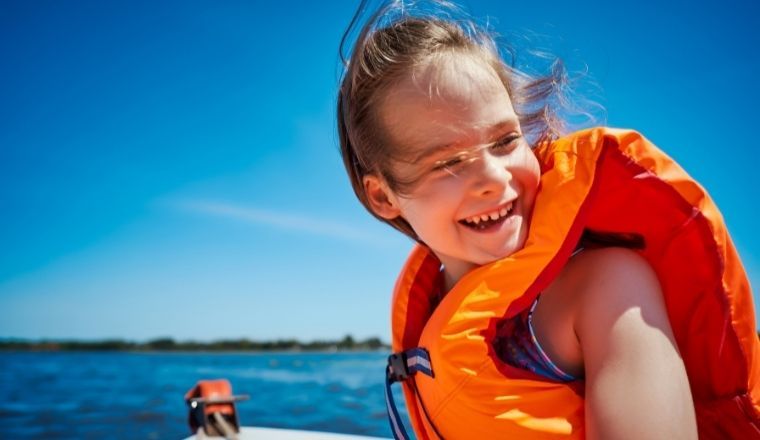 Young girl wearing a lifejacket on a boat.
