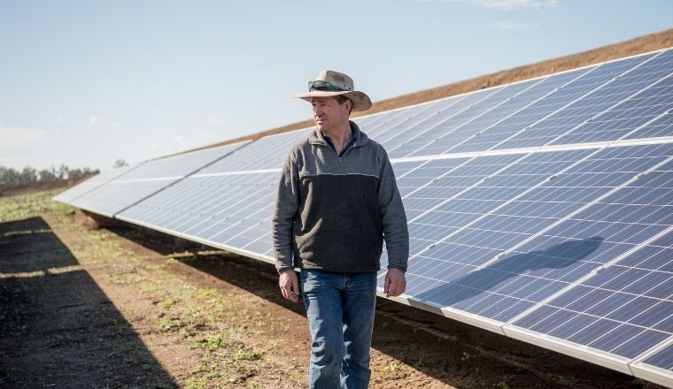 Farmer standing in front of a solar panel