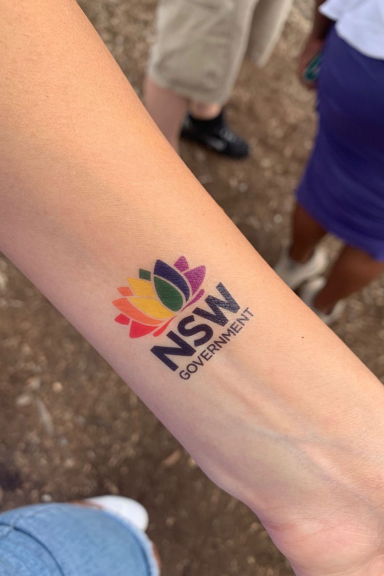 NSW Government rainbow pride logo tattooed on person's arm