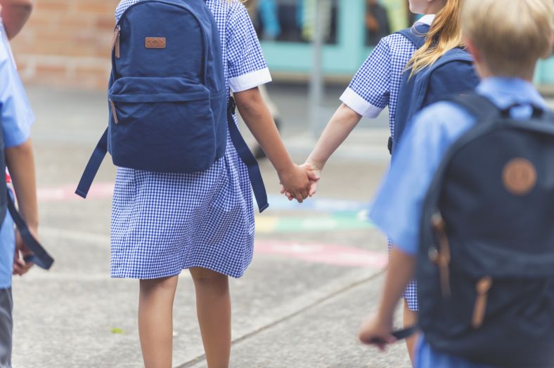 Two primary school students holding hands