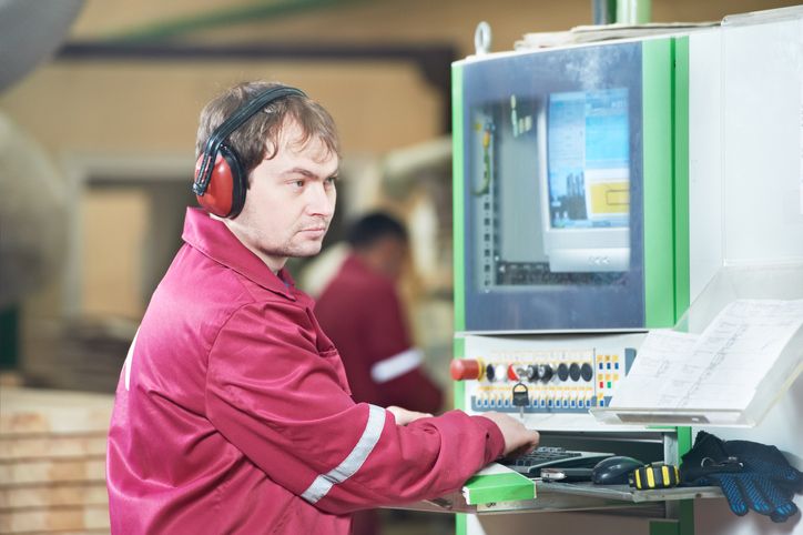Worker wearing noise protection operating machinery