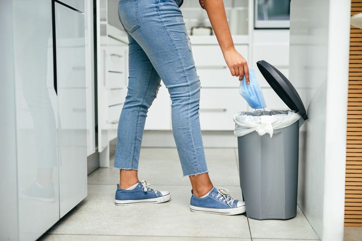 Image of someone using foot to operate hands free rubbish bin 