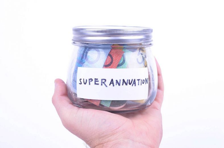 A hand holds a jar labelled 'superannuation' that contains notes of cash
