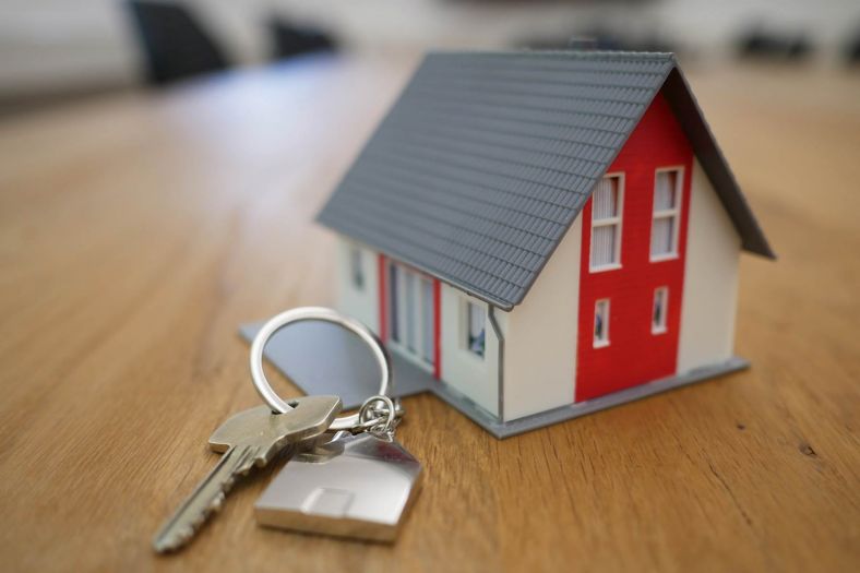 Miniature house on a table with a set of keys