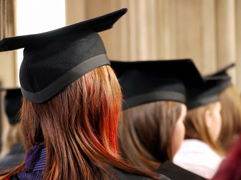 Group of people wearing university graduation hat and clothing