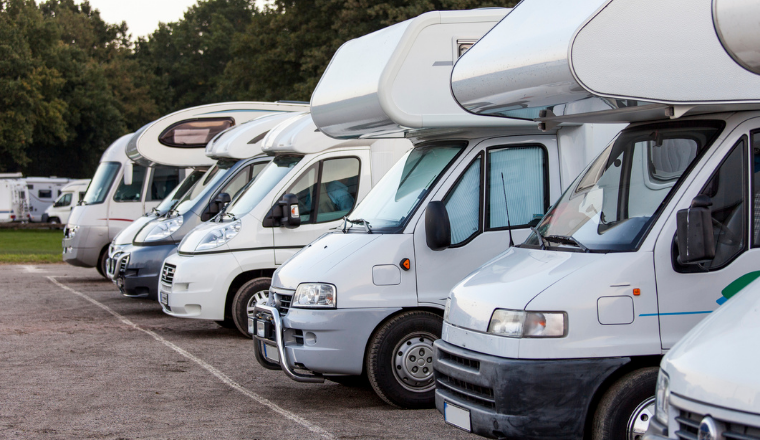 A convoy of motorhomes in a carpark.