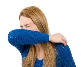 woman sneezing into elbow