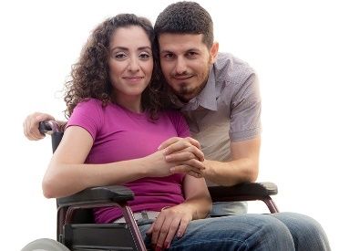 woman in wheelchair being hugged by man
