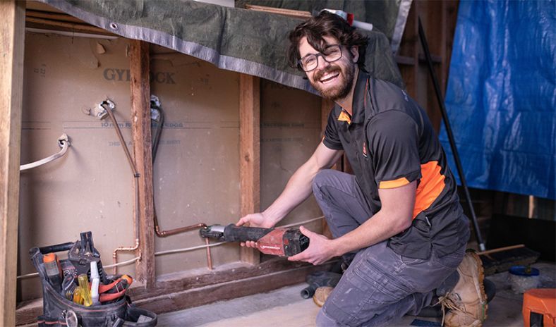 Male plumber fixing pipework
