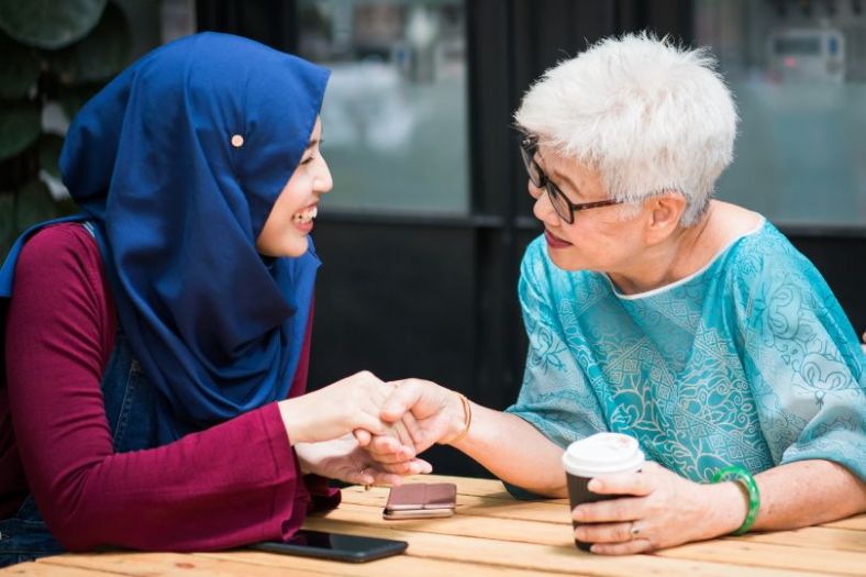 Two women a young muslim and an older lady talk openly